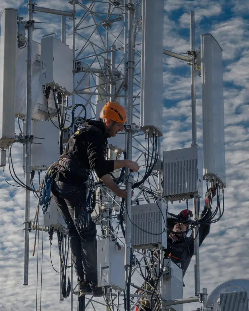Dos técnicos trabajan en las antenas de una torre de telecomunicaciones