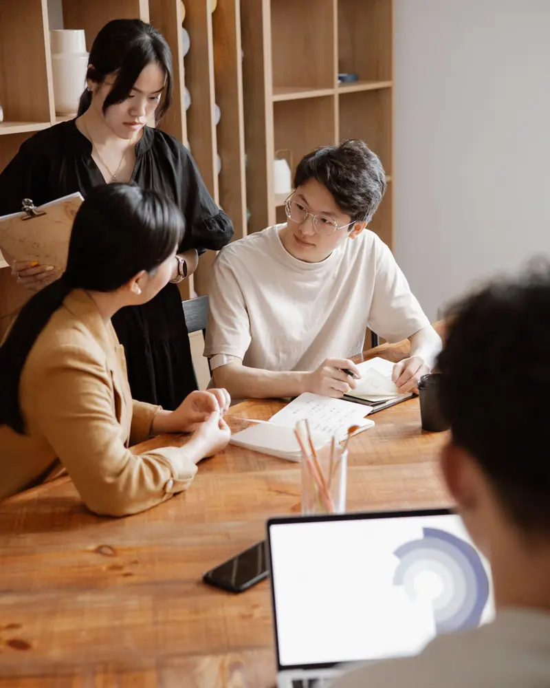 Un equipo de proyecto revisa notas alrededor de una mesa